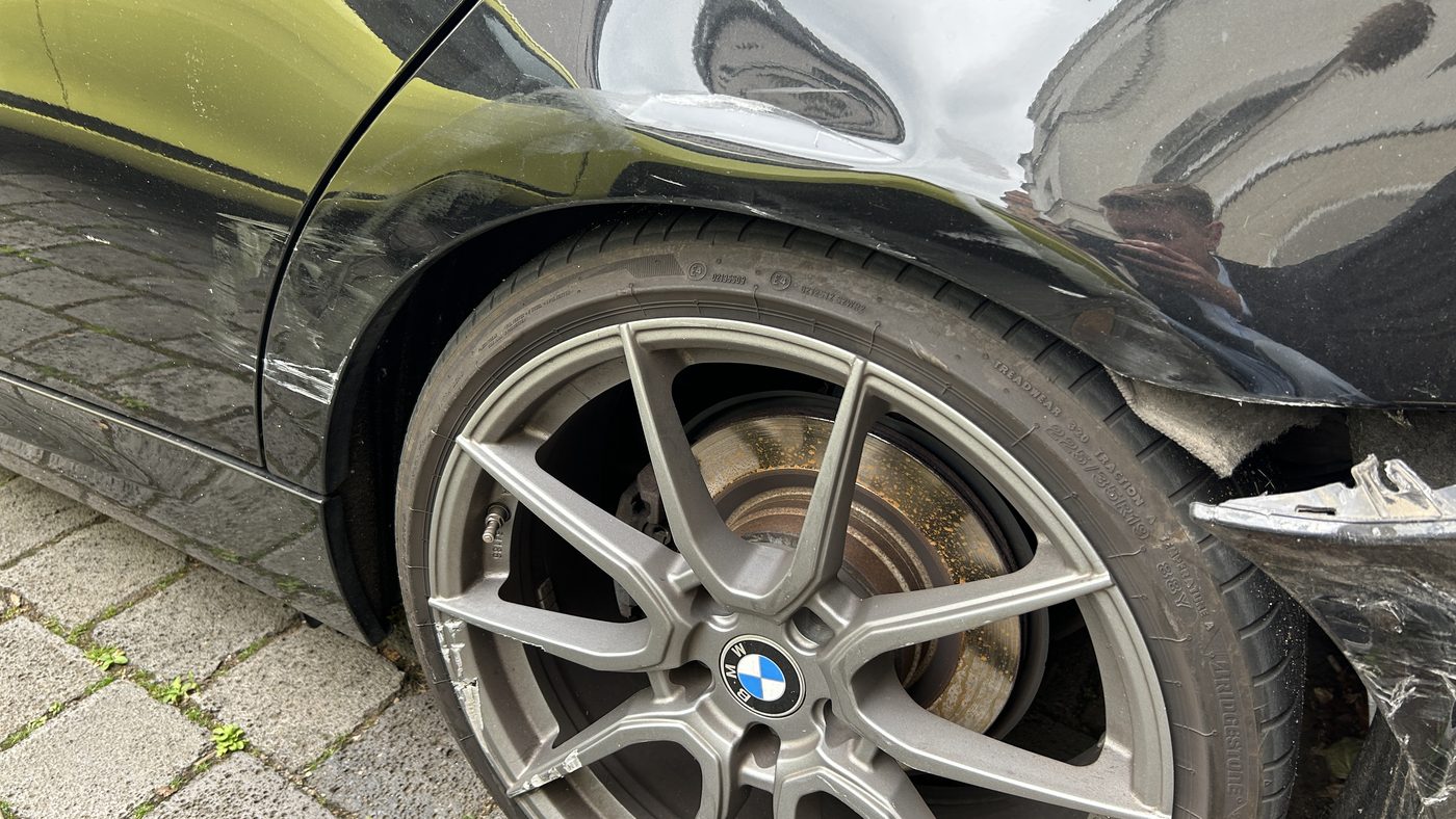 Verformte hintere Seitenwand eines Unfallfahrzeugs mit gerissener Stoßfängerabdeckung