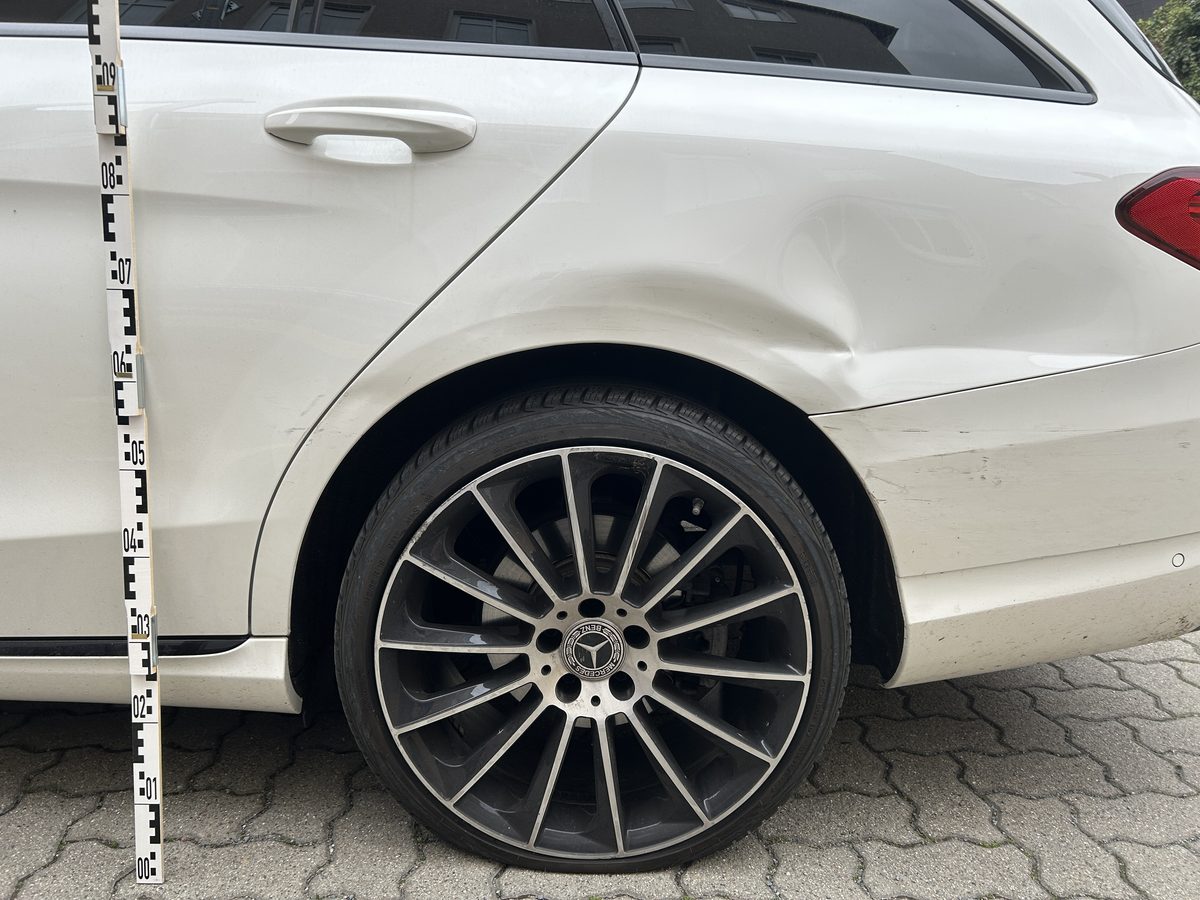 Beschädigte hintere Fahrzeugseite während der Schadenaufnahme